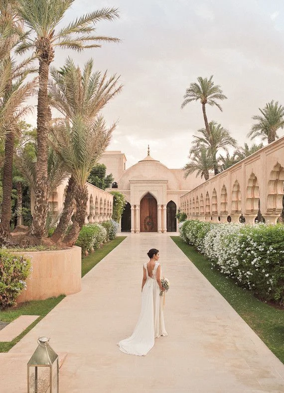 La mariée dans une allée bordée de palmiers