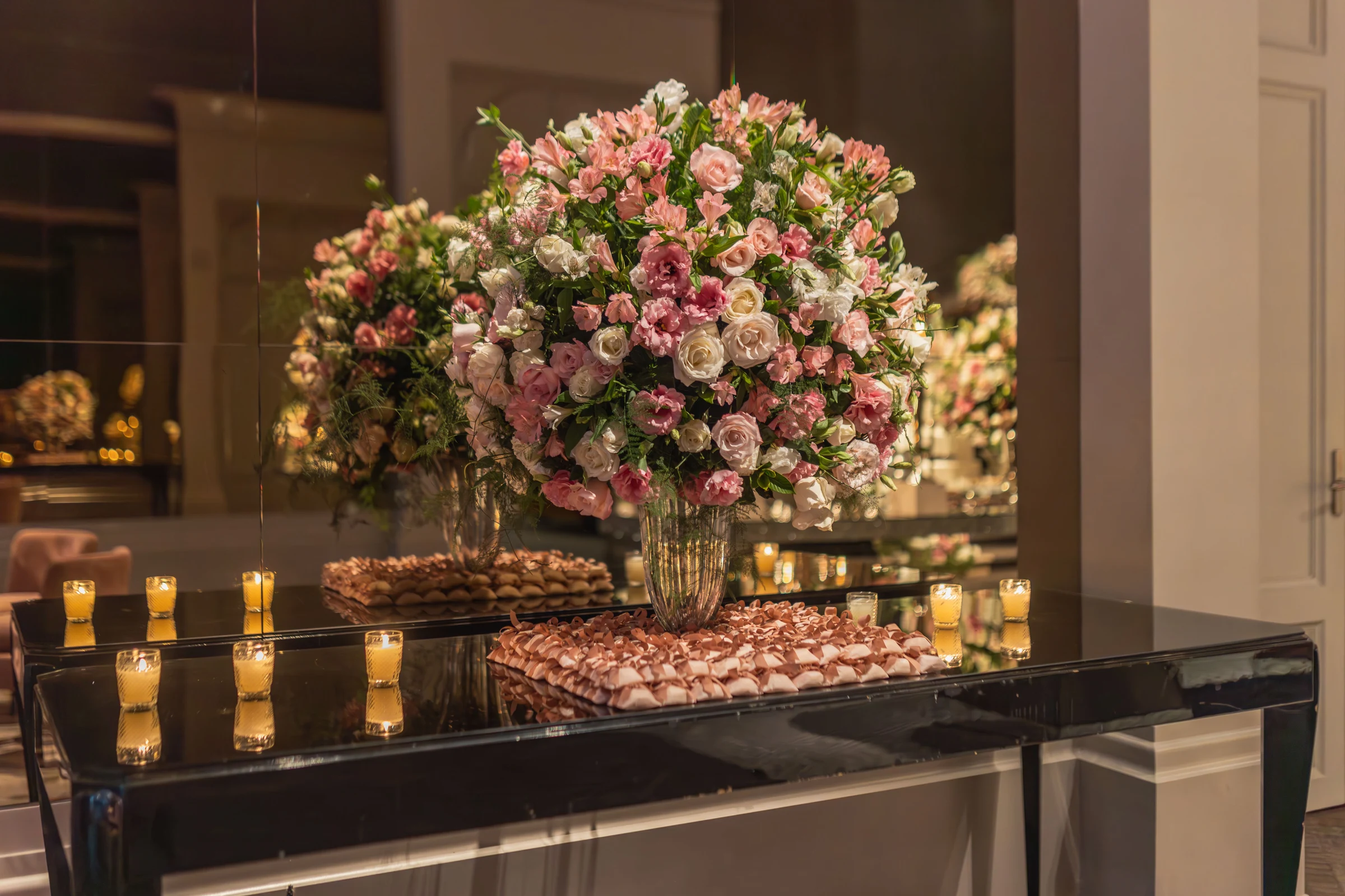 Table de réception décorée d’un grand bouquet de roses et de bougies