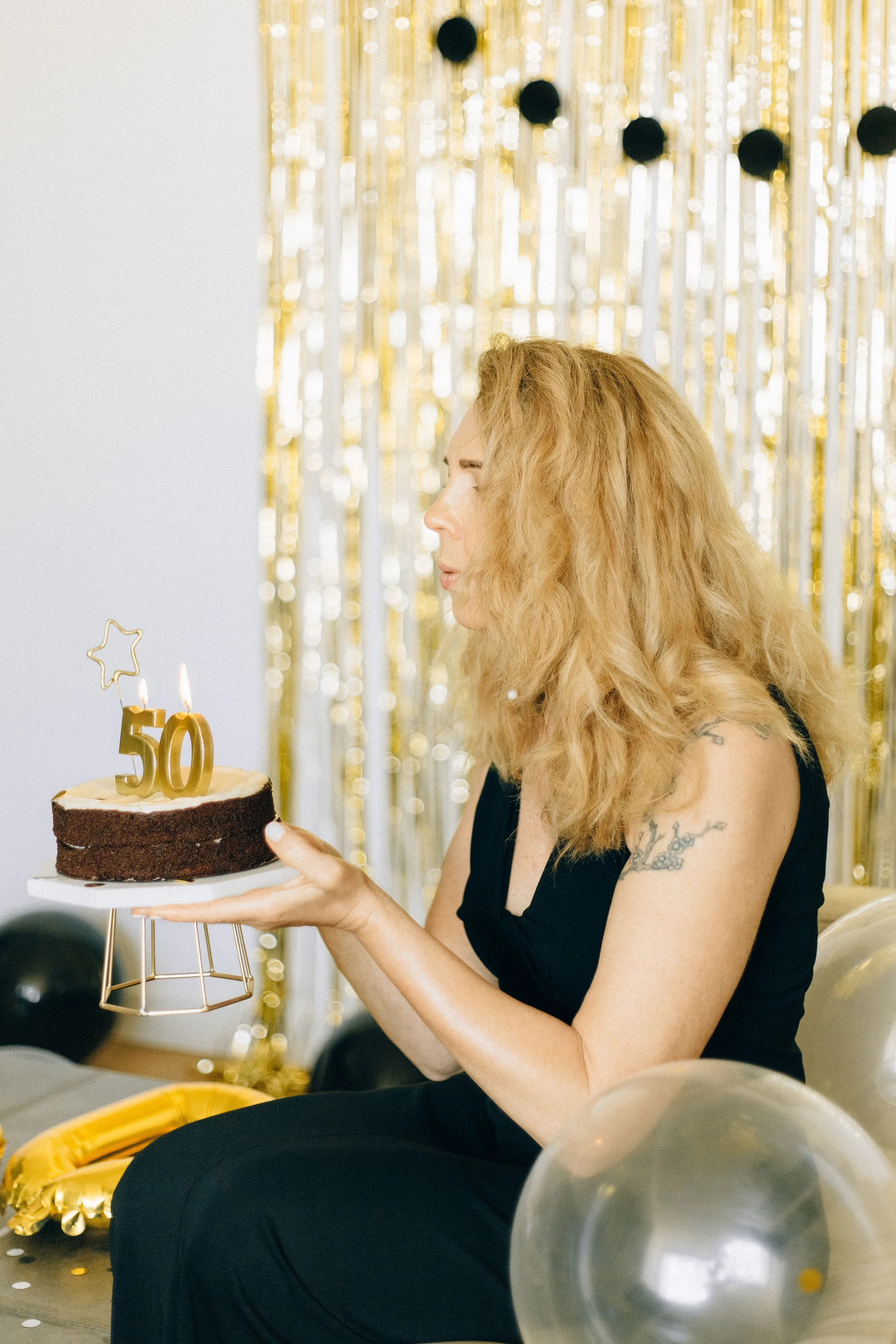 Femme tenant un gâteau d’anniversaire orné du chiffre 50
