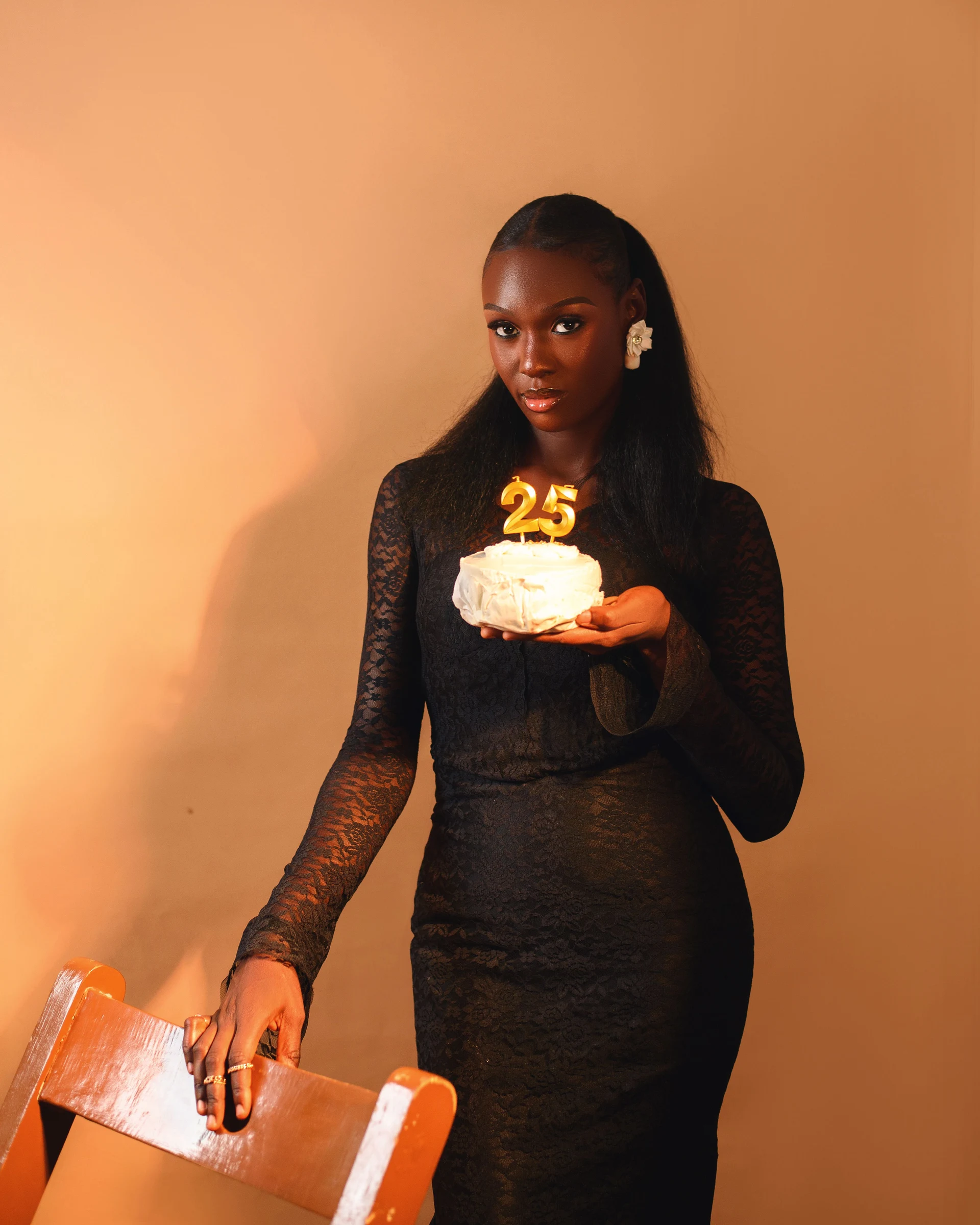 Femme tenant un gâteau d’anniversaire orné du chiffre 25