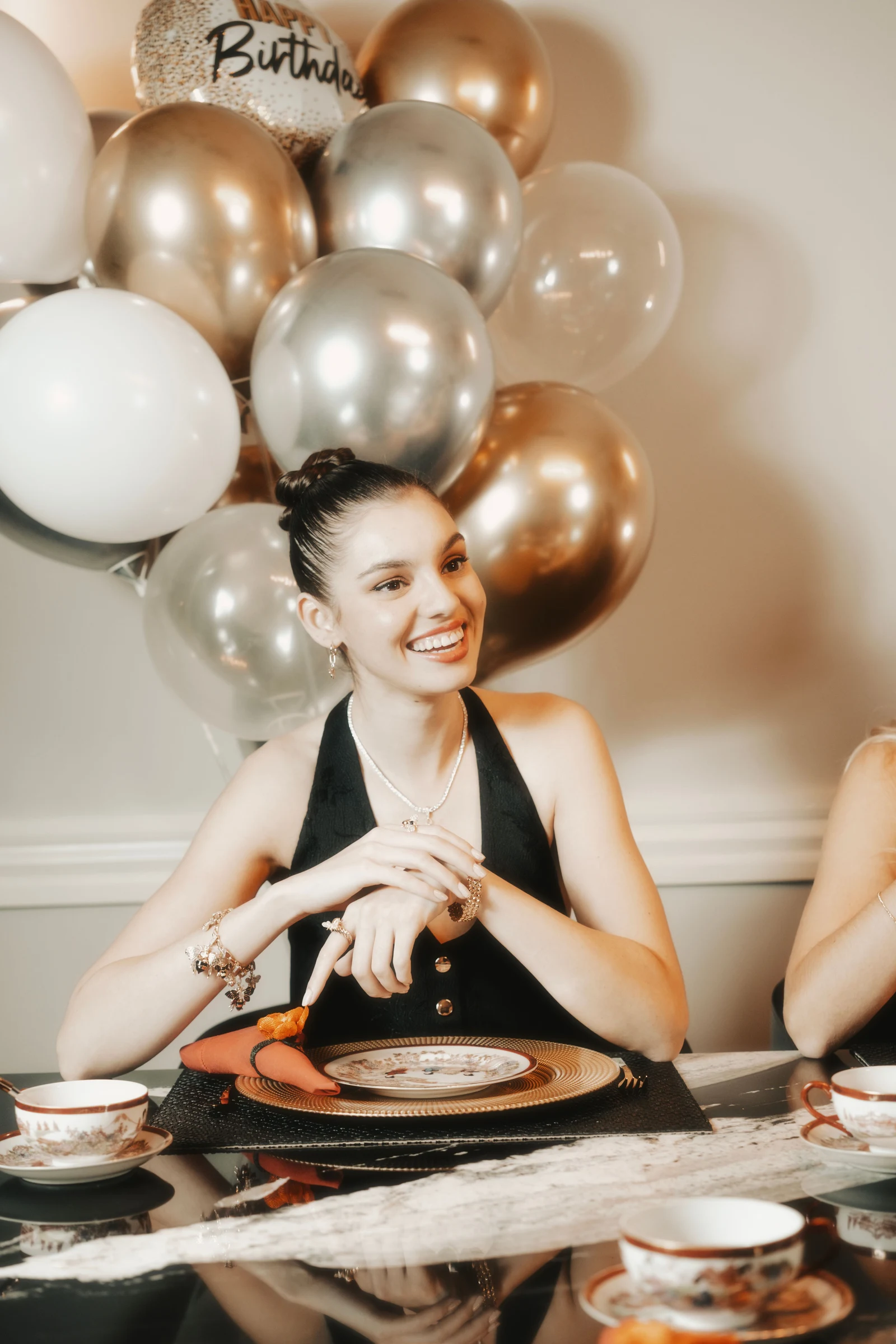 Invitée souriante à une table d’anniversaire décorée de ballons