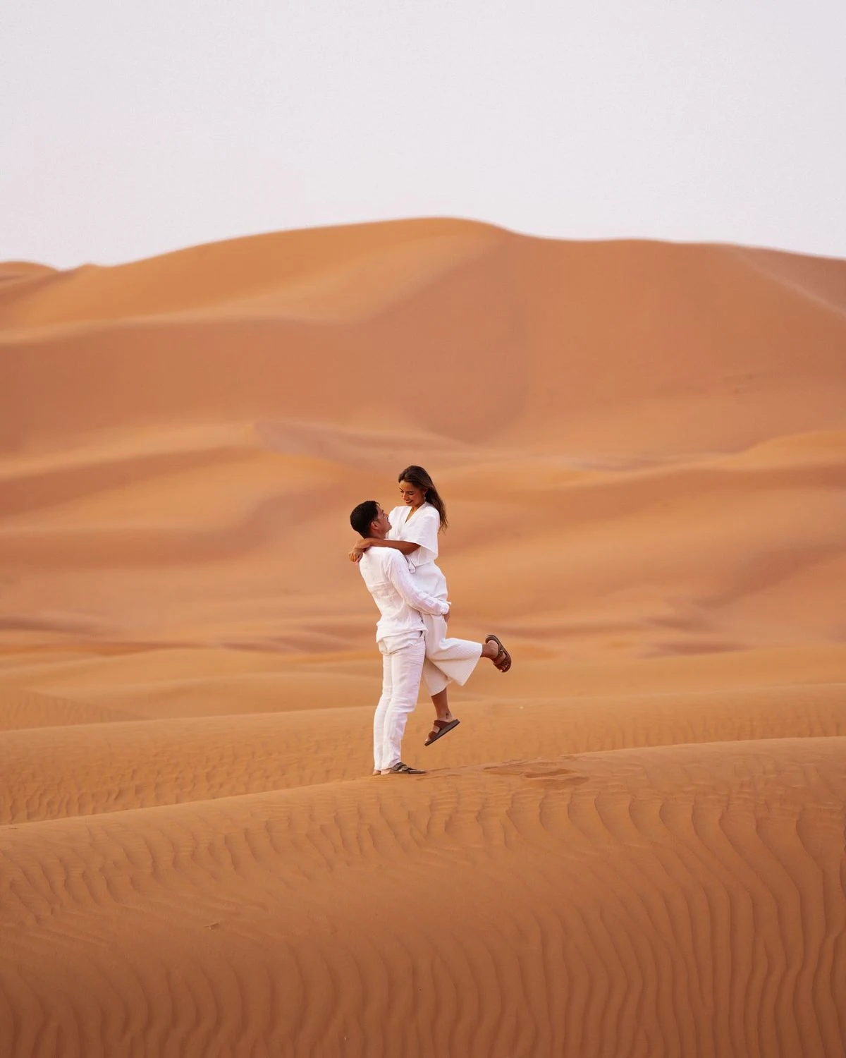 Couple enlacé au milieu des dunes de sable