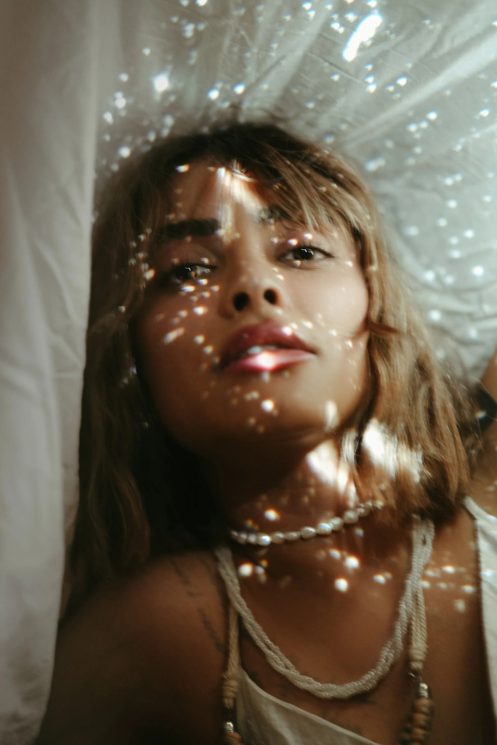 Portrait d’une femme sous des reflets de lumière scintillants
