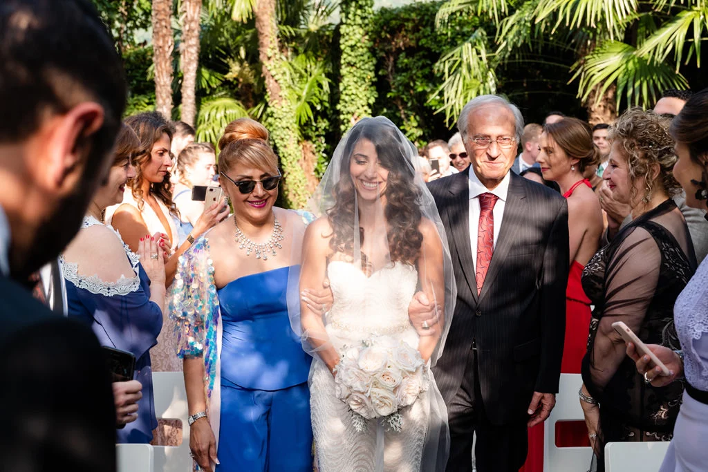 La mariée au bras de son père, entourée des invités